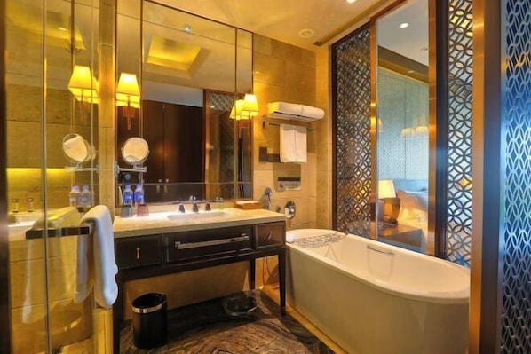 A modern bathroom with a bathtub, a vanity with a mirror, and a shower area.