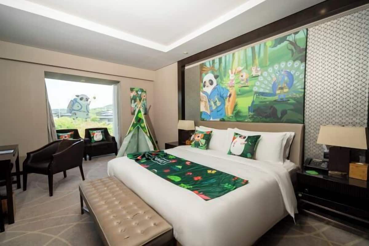A hotel room with a bed, a desk, a chair, a bench, and a large window.