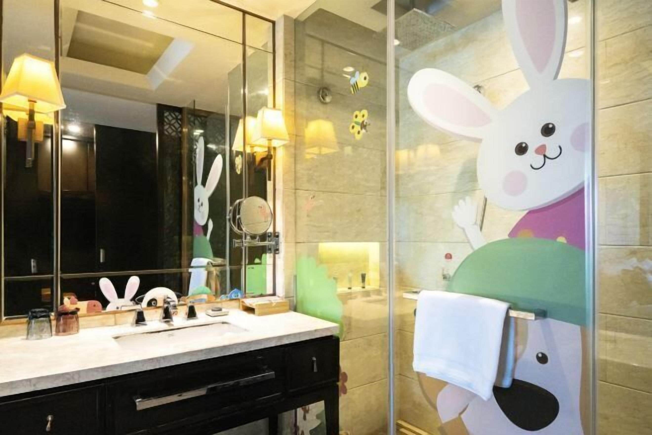Une salle de bain avec un miroir, un lavabo et un porte-serviettes.