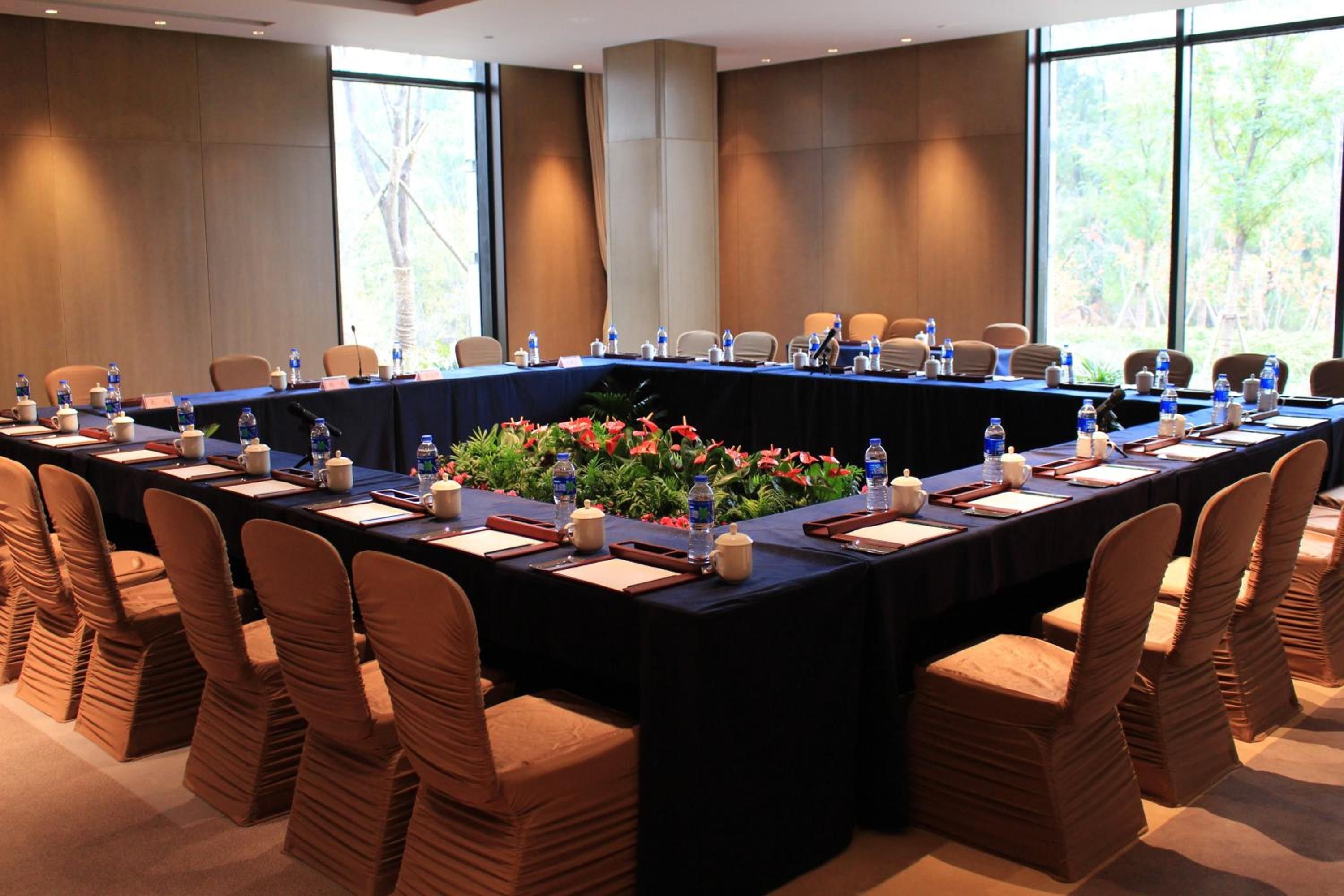 A conference room with a long table, chairs, and water bottles.