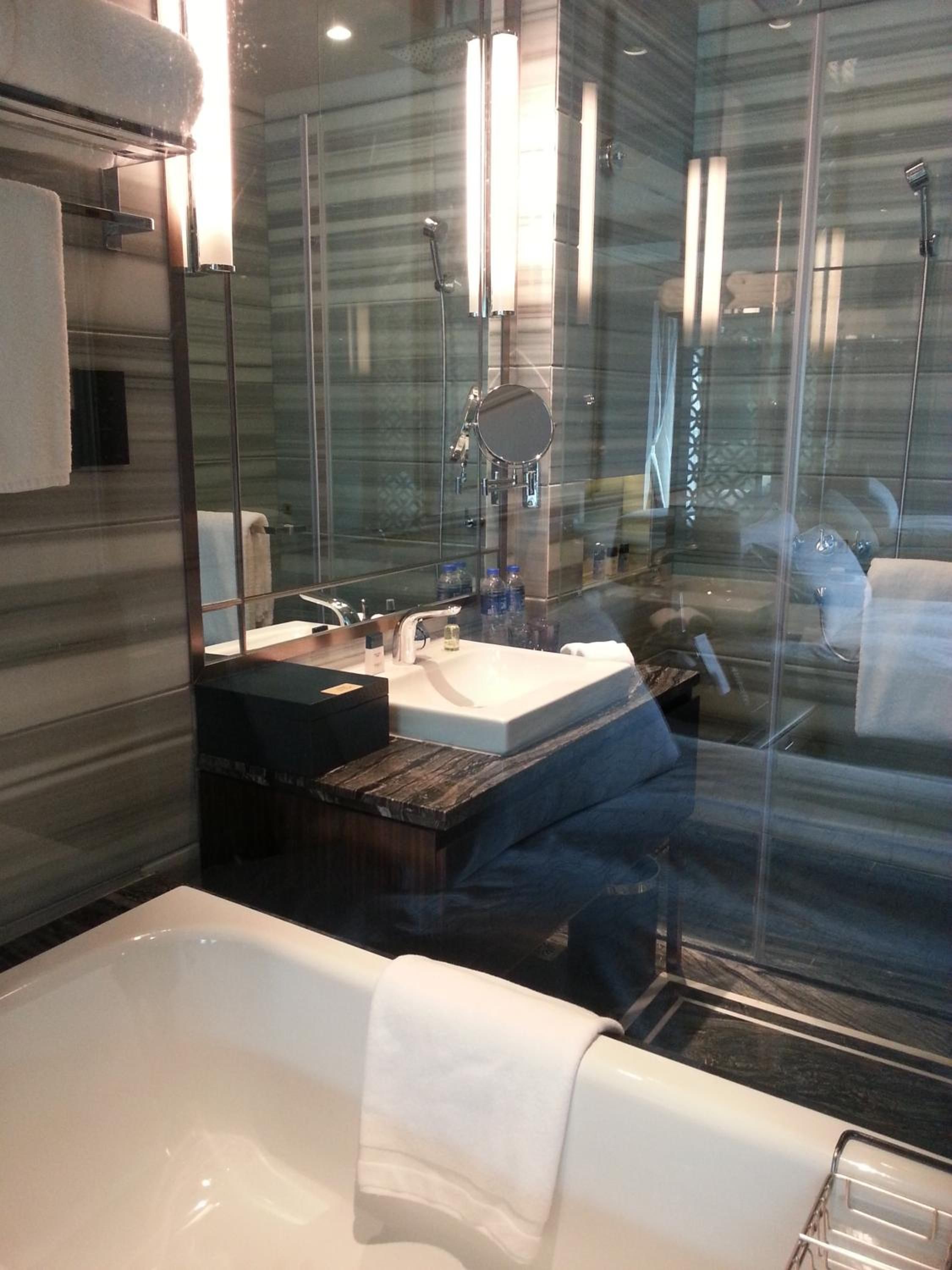 A modern bathroom with a large bathtub, a vanity with a mirror, and a shower area.