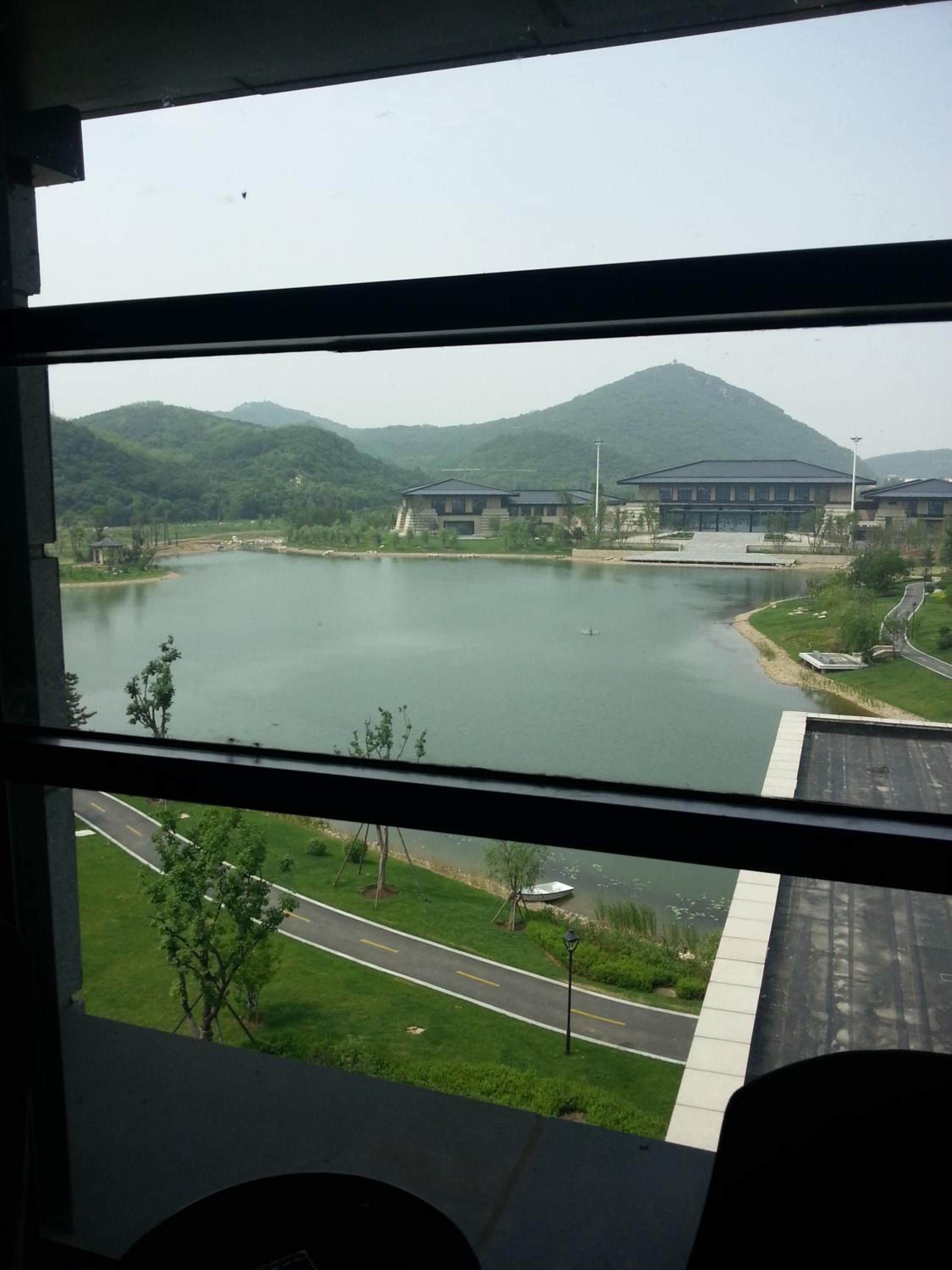 A view of a lake with buildings and a mountain in the background.