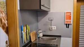 A compact kitchen with a sink, cabinets, and a small countertop. - Vacation apartment Eulennest (Staudernheim)