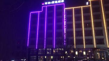 A building with illuminated vertical lines and a sign at the top.