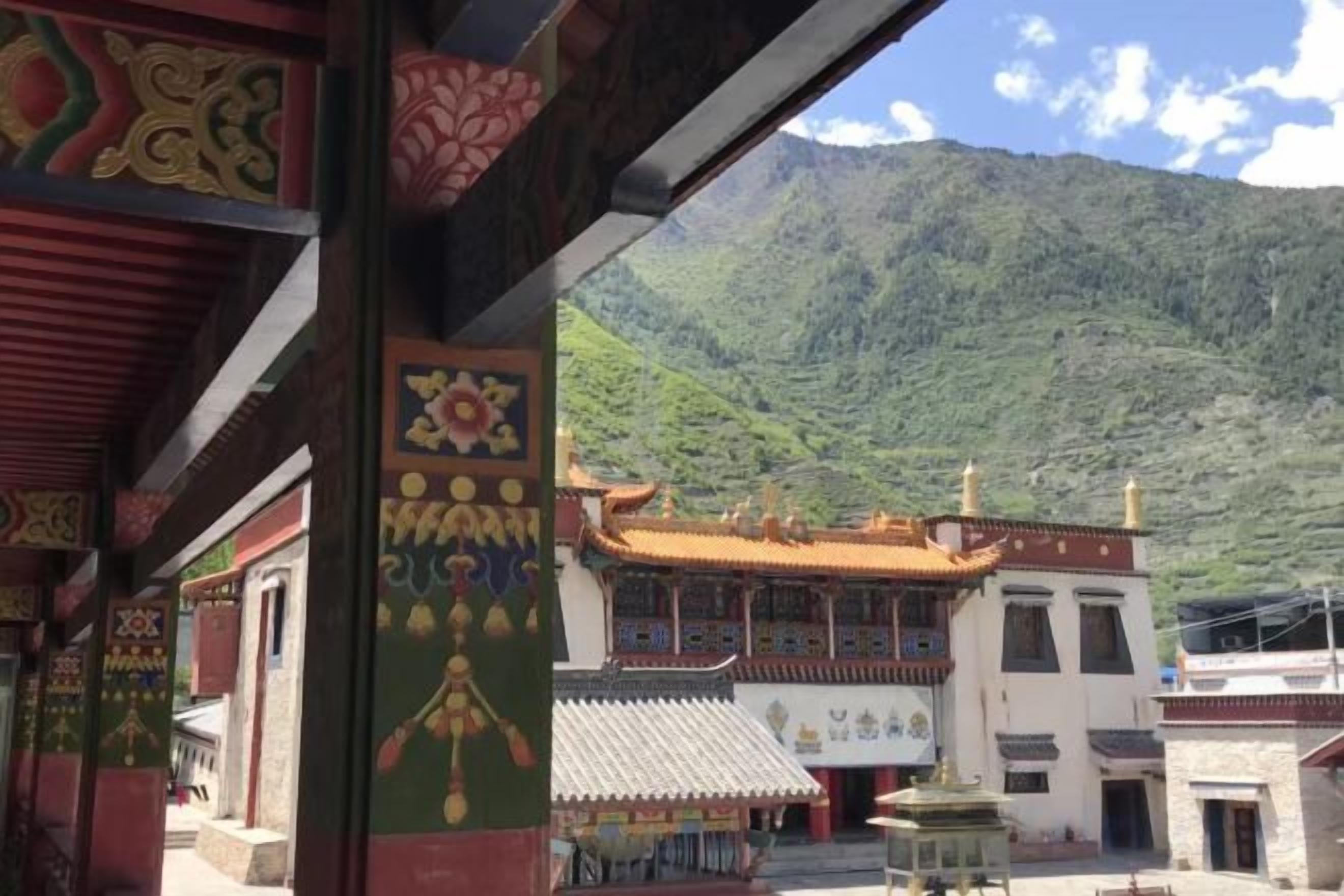 Un edificio tradizionale con facciata rossa e bianca, immerso in un paesaggio montuoso.