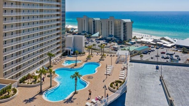 A hotel with a pool area, beach access, and ocean views.