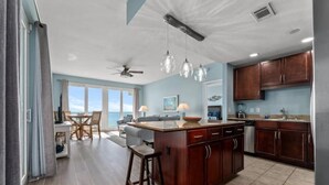 A spacious kitchen with a central island, wooden cabinets, and pendant lighting.