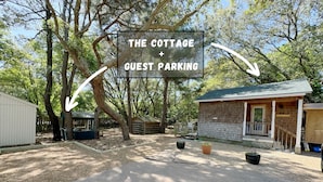 A sign for 'The Cottage + Guest Parking' with a gravel driveway leading to a wooden building and a shed. - Live Oak Cottage - 'tiny house' / walk to beach (Kitty Hawk)