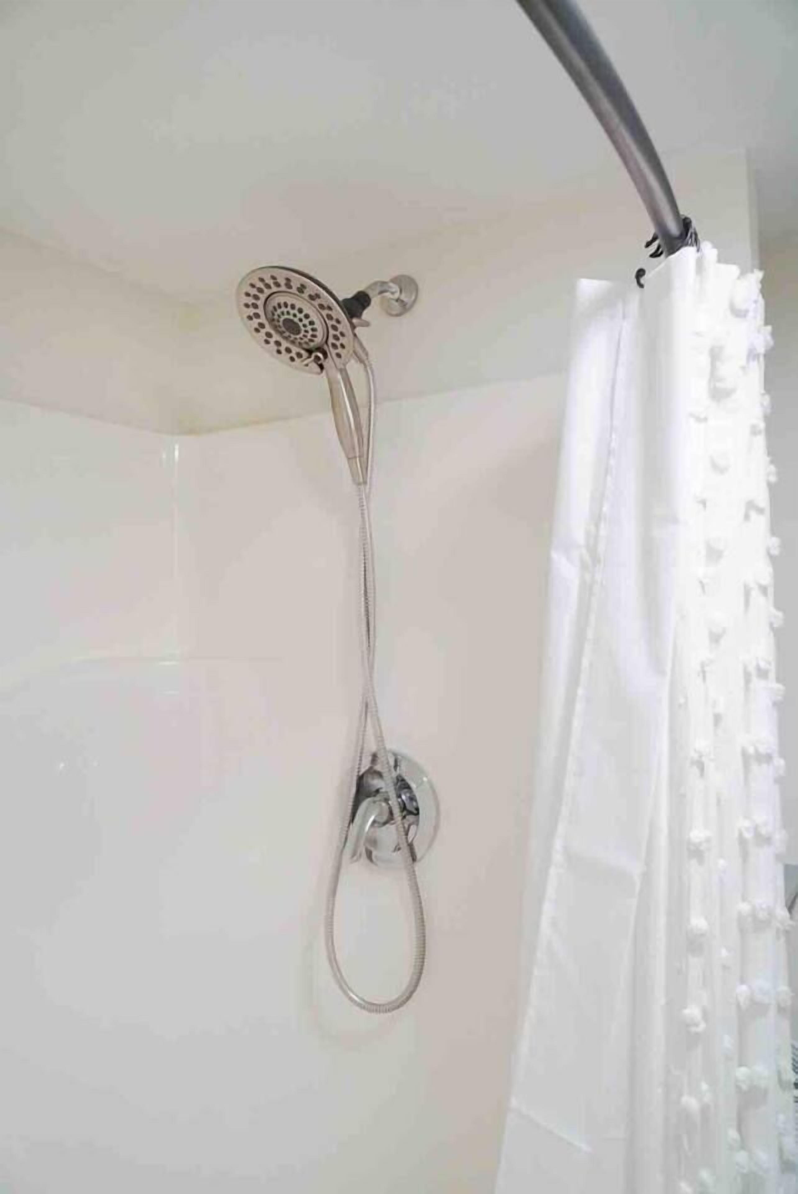 Ducha con cabezal de ducha de mano y cortina.