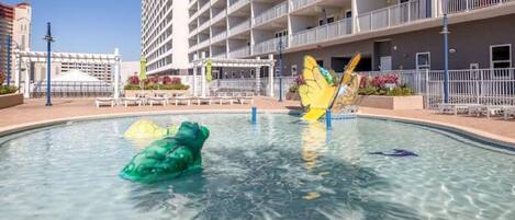 Una piscina con toboganes y una escultura de mariposa.