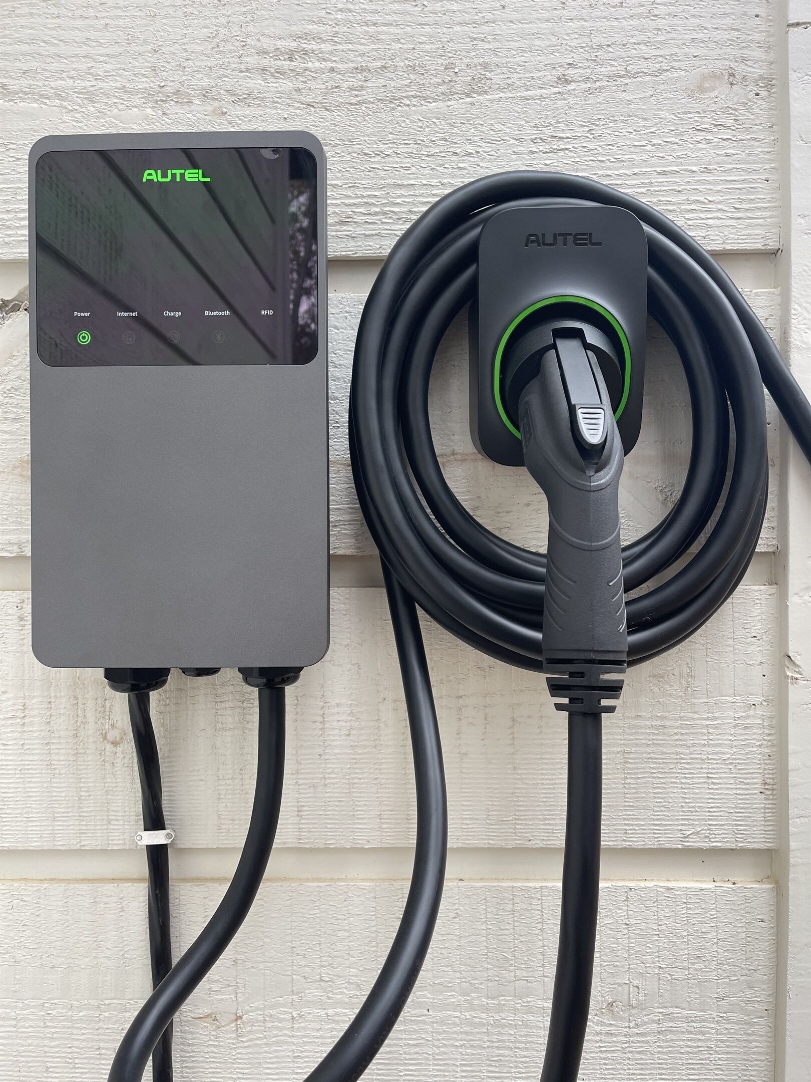 An AUTEL charging station with a control panel and a coiled charging cable.