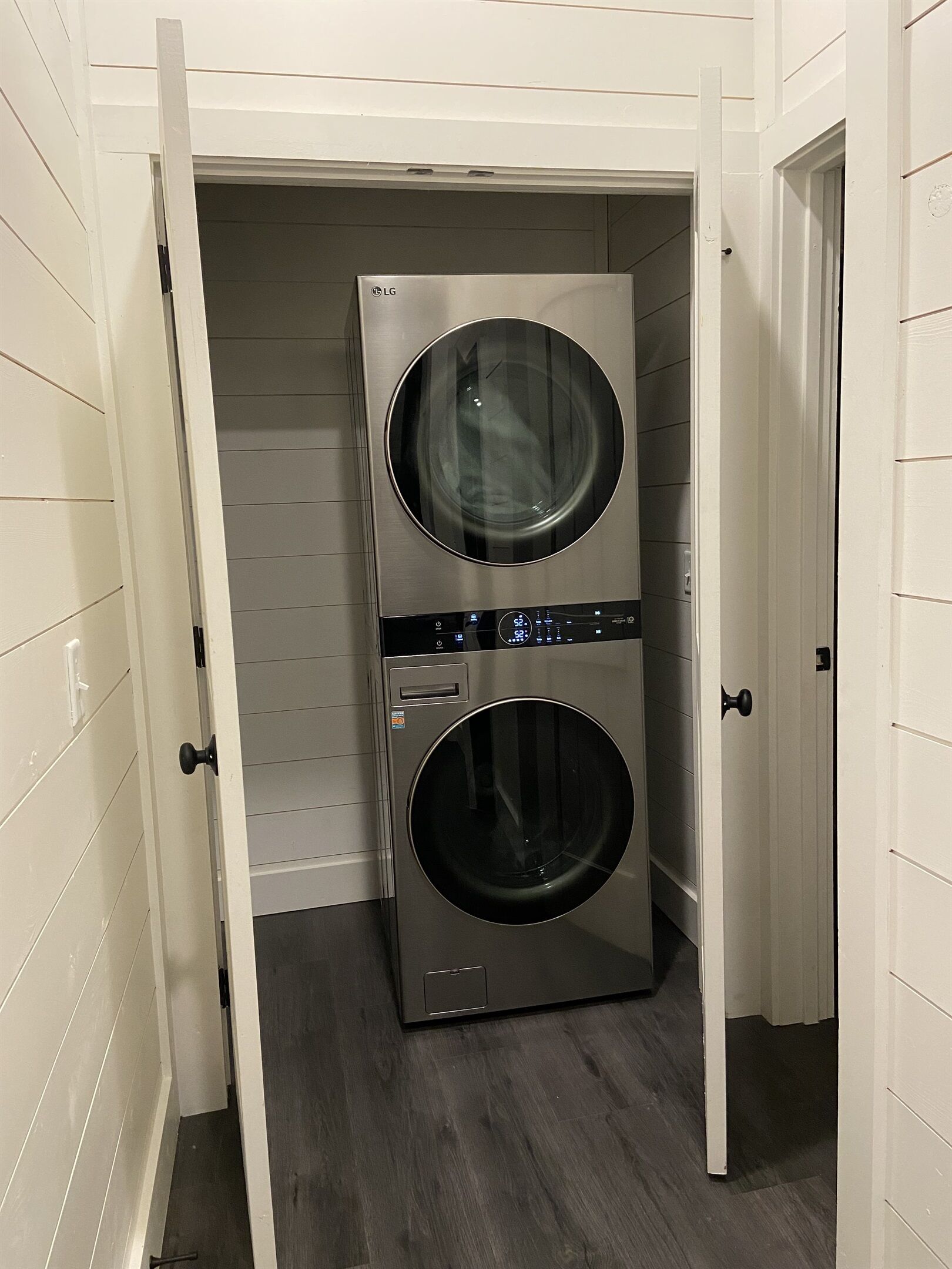 A laundry room with two stacked front-loading washers and dryers.