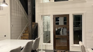 Un intérieur moderne comprenant un coin repas, un escalier et une vue sur l’étage supérieur.