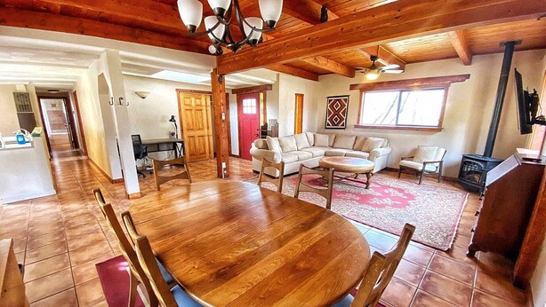 A spacious living area with a wooden dining table, sofas, and a fireplace. - Charming 3 bedroom Ranch in scenic McElmo Canyon (Cortez)