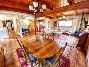 A spacious living area with a wooden dining table, sofas, and a fireplace. - Charming 3 bedroom Ranch in scenic McElmo Canyon (Cortez)