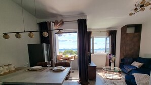 Un salon moderne comprenant un coin repas, un canapé et un téléviseur.