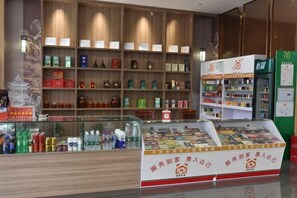 A hotel lobby with wooden shelves displaying various products and a glass display case with magazines.