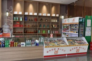 Una farmacia con estantes llenos de diversos productos, una vitrina con bebidas embotelladas y un letrero con caracteres chinos.