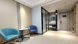 A modern hotel room with a sofa, a small table, and a seating area. - Alant Hotel (Duyun)