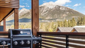 A Coleman gas grill on a balcony with a mountain view. - "Tranquil Tamarack" at Tamarack Lodge (Canmore)