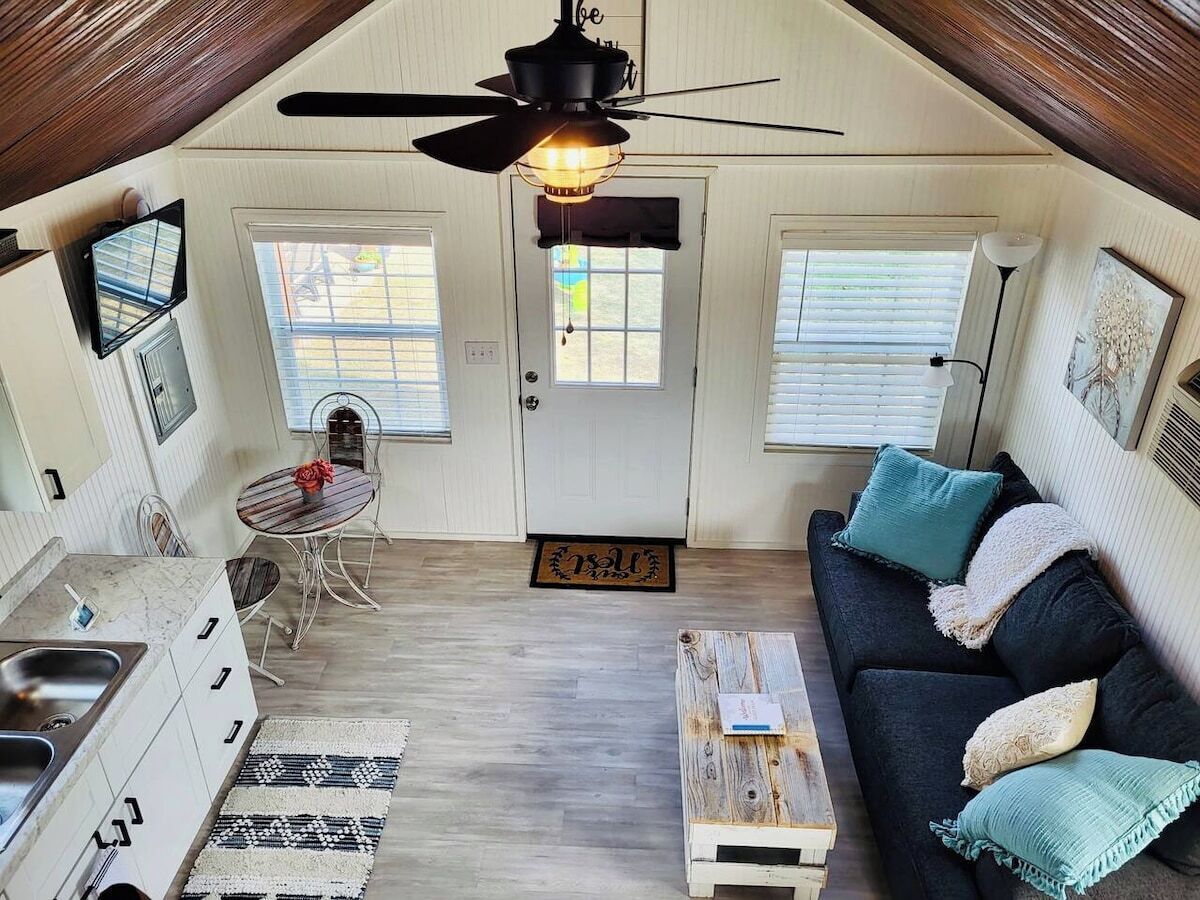 A compact living space with a kitchenette, a dining area, and a seating area with a sofa and coffee table.