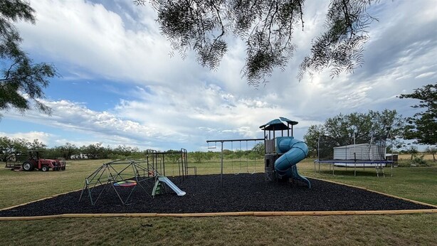A playground with a slide, swing set, and climbing structure. - Adorable tiny house (with loft!) near Potosi Live (Abilene)