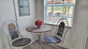 A dining area with a round table and two chairs with metal frames and wooden seats. - Adorable tiny house (with loft!) near Potosi Live (Abilene)
