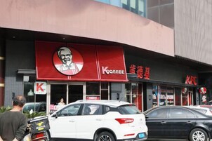 Un restaurante KFC con un letrero rojo llamativo y un logotipo grande.