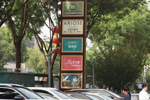 Un panneau vertical comportant plusieurs publicités, dont une pour « ARIOSE YEARS » et une autre pour « WATSONS ».