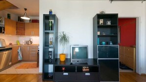 A modern kitchen with wooden cabinets, a built-in dishwasher, and a small dining area. - Cosy, sunny two-story apartment, 20min center (Hlavní mesto Praha)