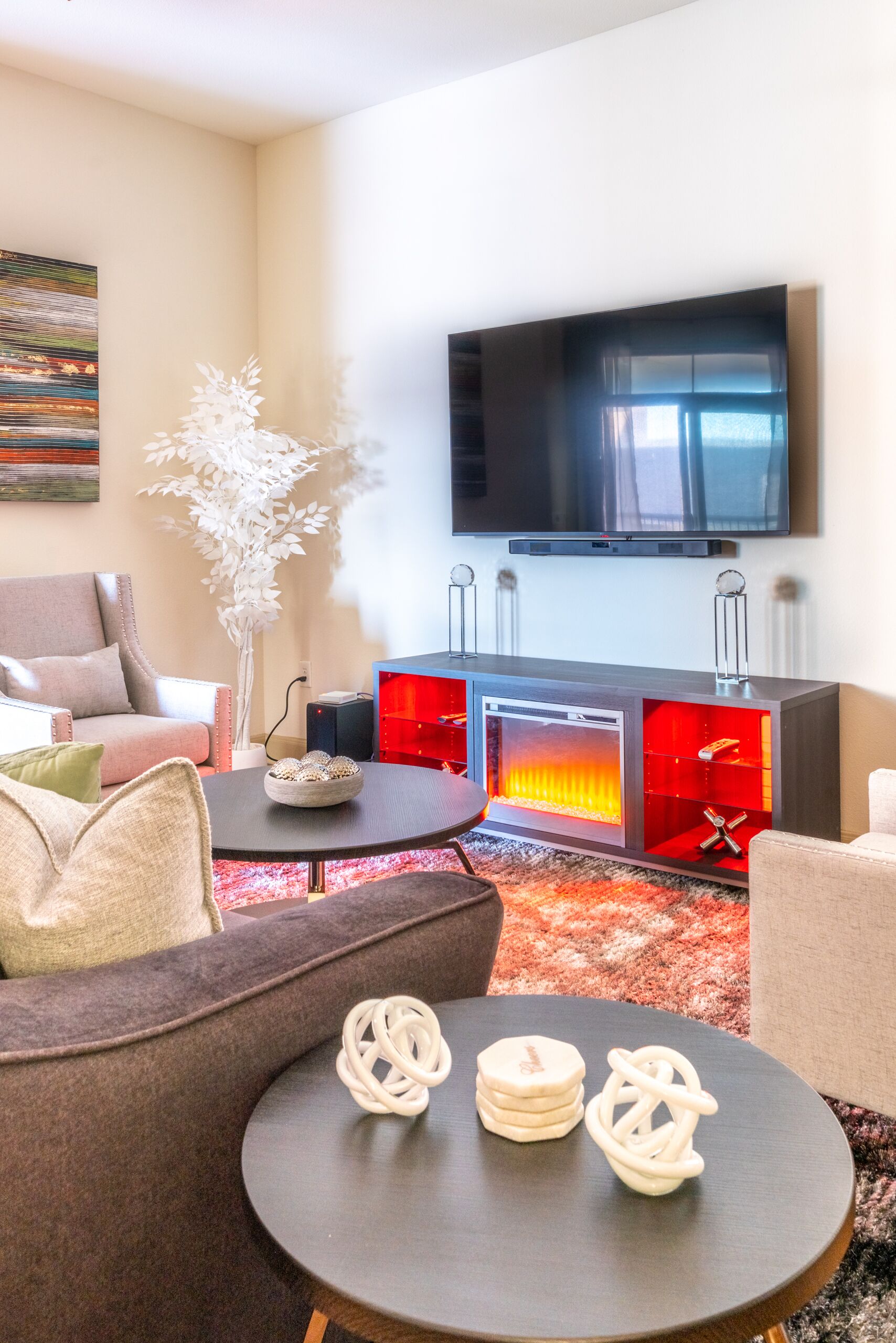 Una sala de estar moderna con un televisor de pantalla plana, una chimenea y un sofá.