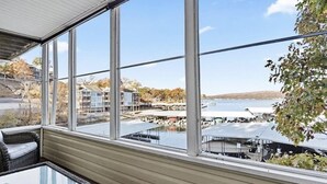 Ein Zimmer mit großen Fenstern und Blick auf eine Marina mit Booten und Stegen.