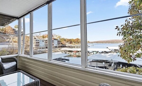 A room with large windows overlooking a marina with boats and docks.