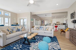 Un salon moderne avec un canapé, une table basse et un tapis bleu à motifs.