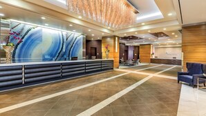 A modern reception area with a large abstract painting, a reception desk, and a seating area with chairs. - 1BD/Vegas - Full Kitchen, Washer/Dryer, and Private Living Room! (Las Vegas)
