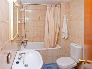 Ein Badezimmer mit Badewanne, Toilette, Waschbecken und Dusche.