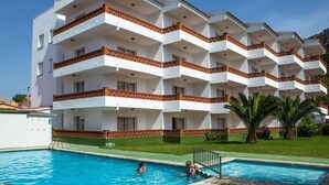 Un hôtel à plusieurs étages doté de balcons, d’une piscine et d’une pelouse verdoyante.