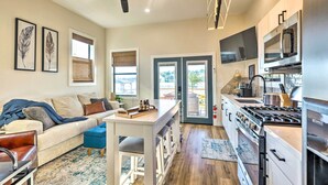 A modern kitchen with a stove, microwave, and dining area. - New-Build Waterfront Cabin, Lake Conroe (Willis)