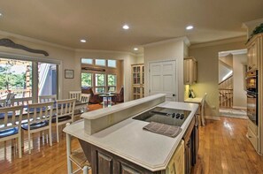 Enjoy meals in the kitchen with a stove and ample counter space, adjacent to a dining area with a table and chairs.