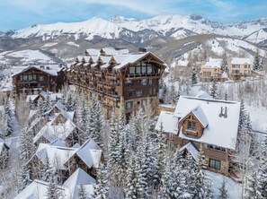 A lodge with multiple wooden buildings, snow-covered trees, and a mountainous backdrop. - Spacious & Private 4-bedroom home in Village Core. Walk to Lifts & Gondola! (Mountain Village)