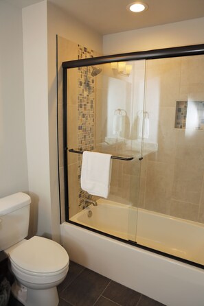 Bathtub, hair dryer, towels, toilet paper