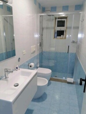 Een douche, een haardroger, een bidet, handdoeken