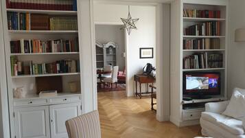Un soggiorno con una grande libreria, una televisione e un'area pranzo.