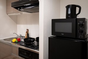 Prepare meals in this compact kitchen with a microwave and coffee maker, perfect for hot beverages.