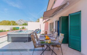 Enjoy a casual meal in our outdoor dining area, surrounded by a serene mountain view and a relaxing hot tub nearby.