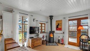 Ett mysigt vardagsrum med en öppen spis, trämöbler, en tv och en jordglob på ett stativ.