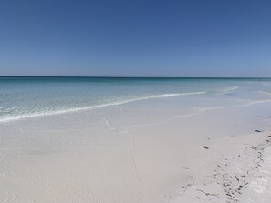 Uma praia com águas azul-claras e areia branca.