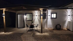 An outdoor patio area with a covered seating area, a door, and a wall-mounted light fixture. - 3 Bedrm, 2 Bath, 6 Guest House by Cubs Spring Training Stadium, ASU, Scottsdale  (Mesa)