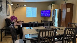A modern living room with a dining area, a flat-screen TV, and a refrigerator. - 3 Bedrm, 2 Bath, 6 Guest House by Cubs Spring Training Stadium, ASU, Scottsdale  (Mesa)