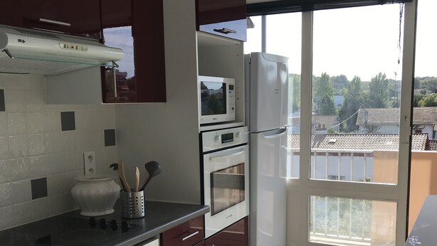 A modern kitchen with a washing machine, microwave, oven, and refrigerator. - Beautiful apartment in the center of Anglet, 10 minutes from the beach (anglet)